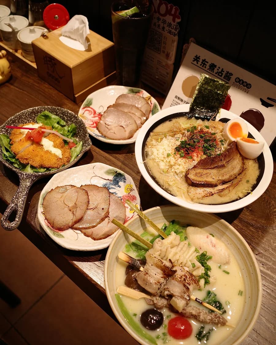 Japanese ramen and small dishes arranged on a wooden dining table